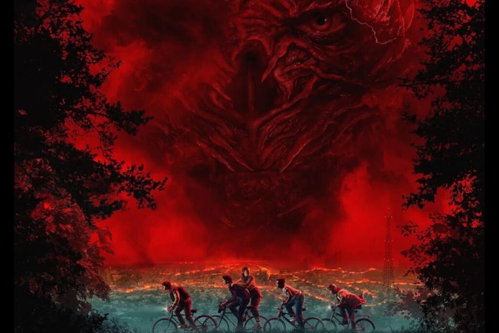 image showing a group of kids on bicycles, with town in the background, against a crimson red sky in which one can see the outlines of a cadaverous evil face leering down on them.