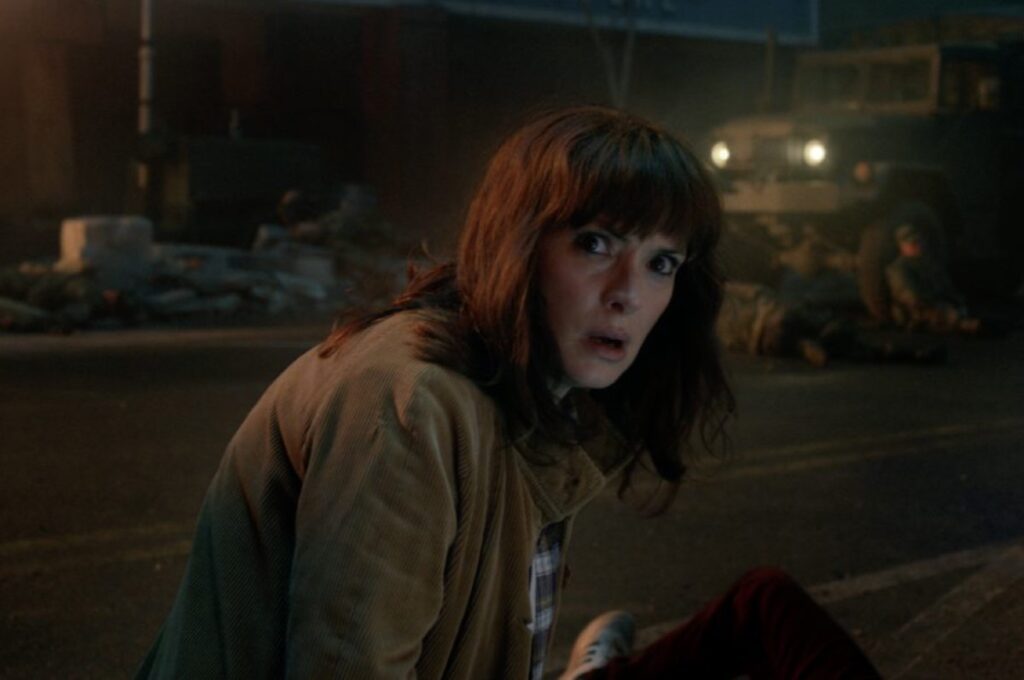 middle aged woman on a dark street looking scared yet resolute.