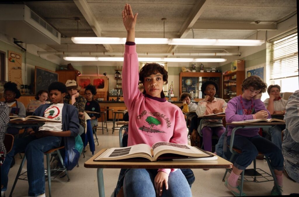 teen black girl raising her hand in a classroom