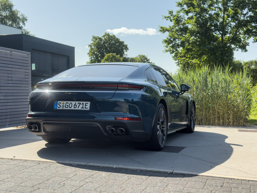 A blue Porsche Panamera Turbo S seen from the rear, in the sunshine