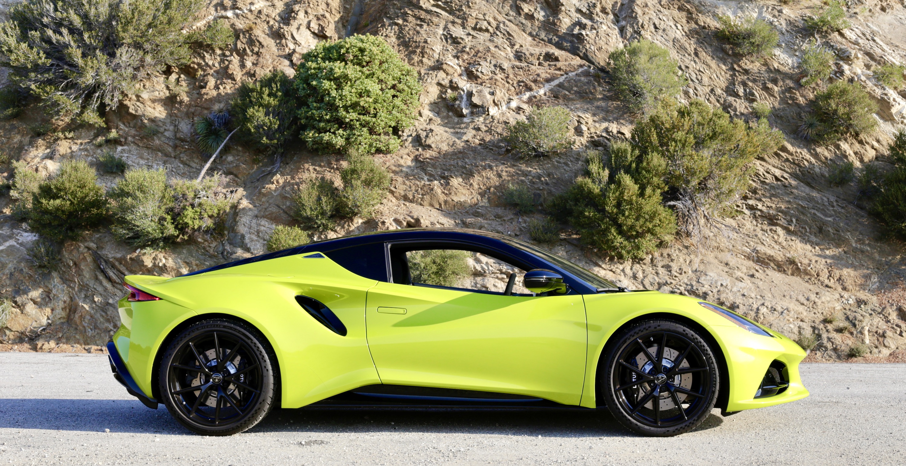 A lime green Lotus Emira in profile