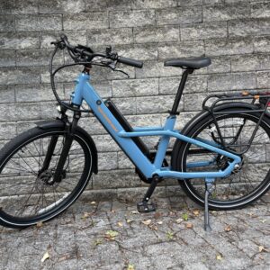 Image of a light blue bicycle in front of a grey stone wall.