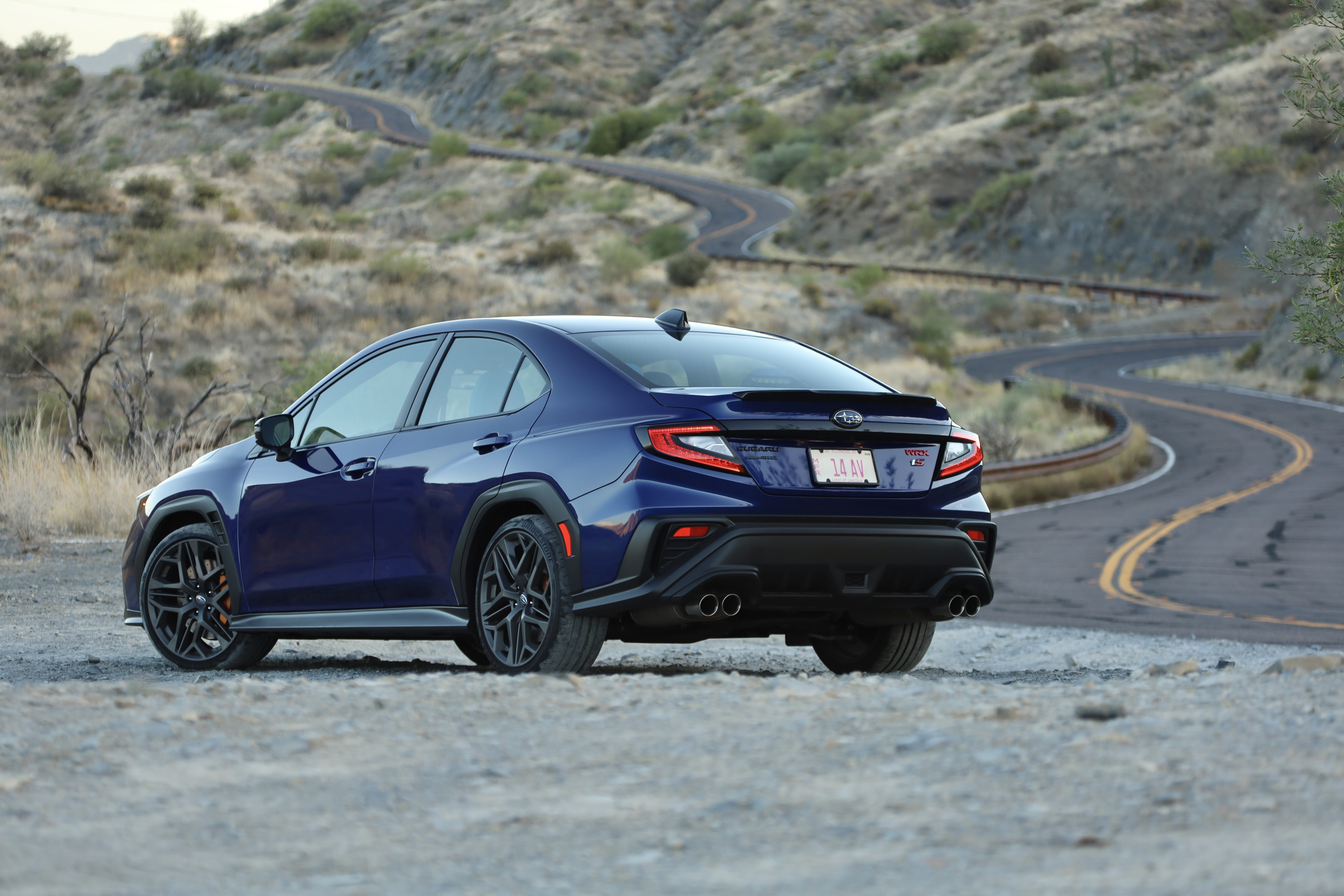 A blue Subaru WRX seen from the rear 3/4s