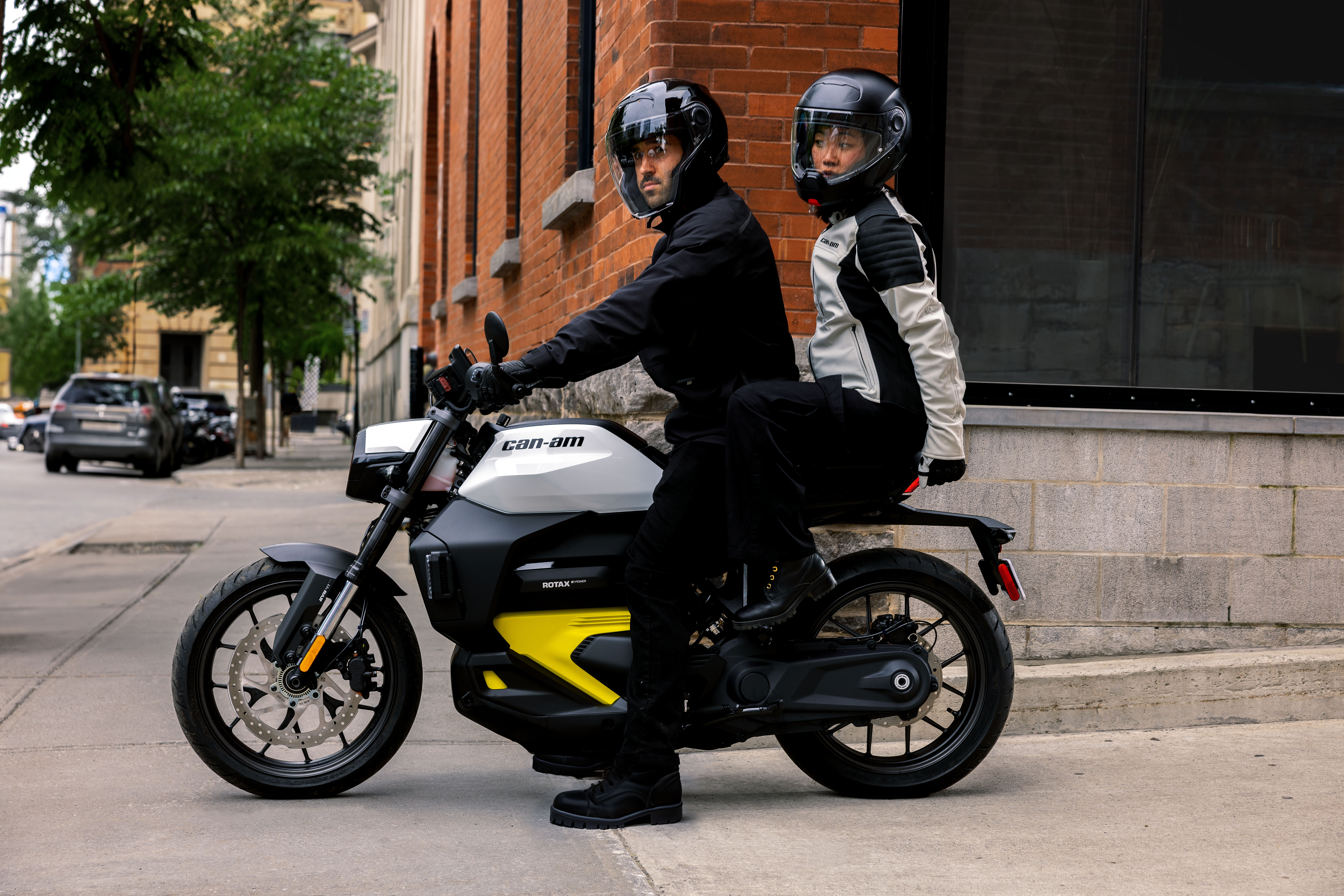A man and a woman ride on an electric motorcycle in the city