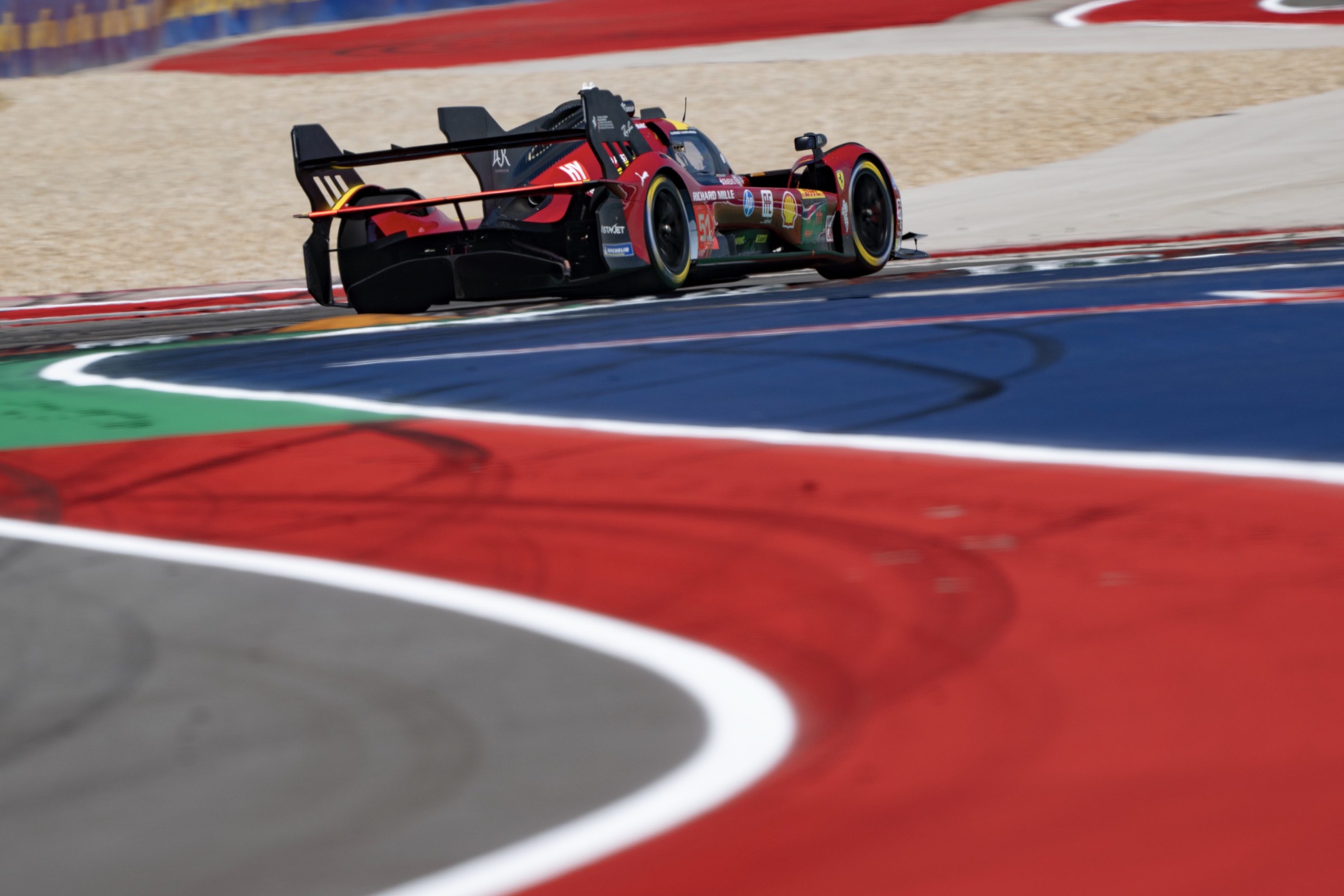 A Ferrari 499P seen from behind, on track at COTA