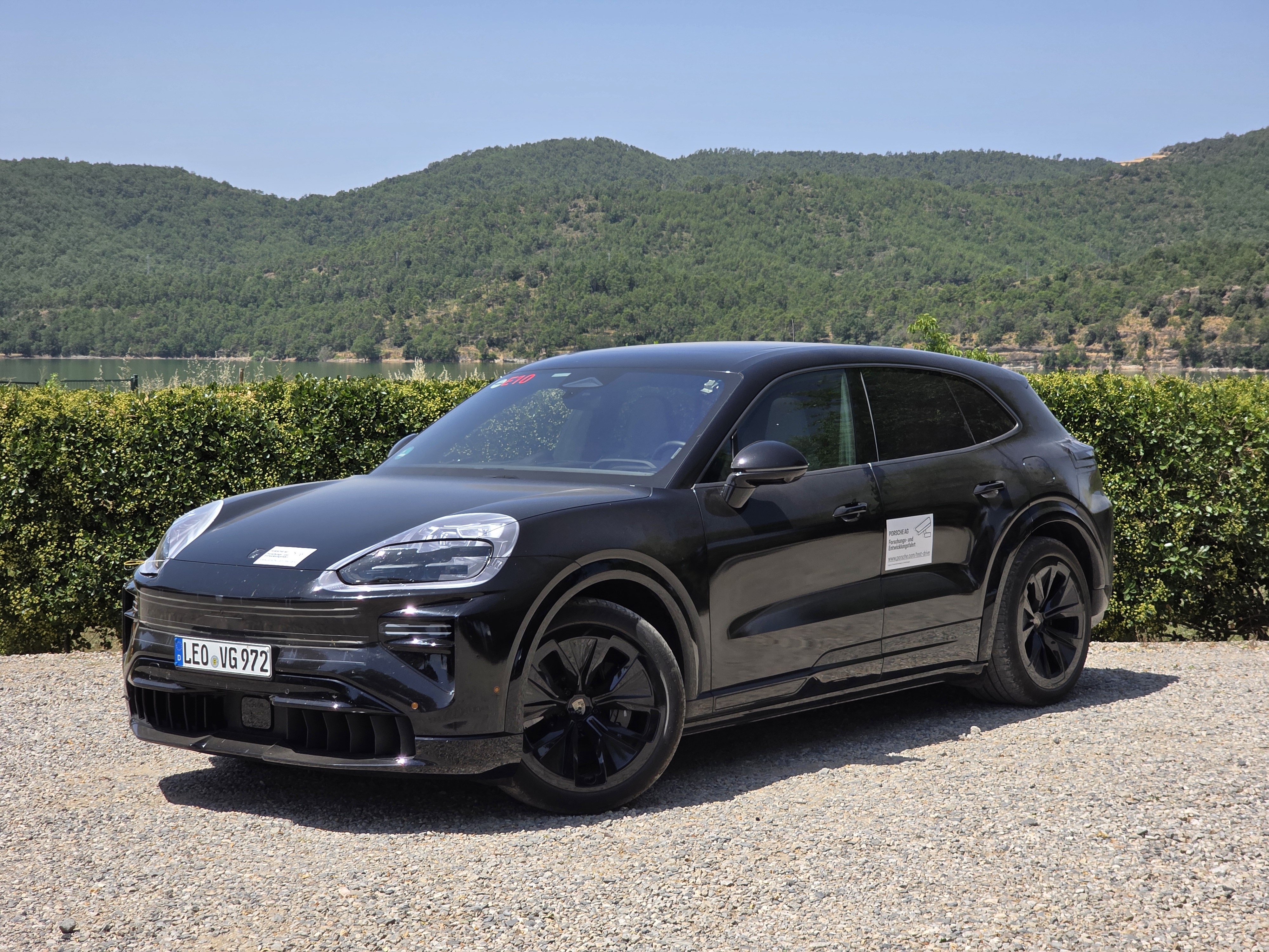 A Porsche Cayenne Electric prototype parked by the side of the road.