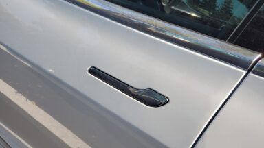 Close-up of flush-mounted, retracting door handle on Tesla automobile