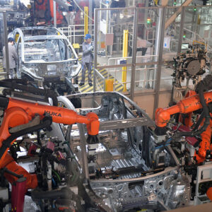 Image of an assembly line where two robots are coordinating the production of an automobile frame.