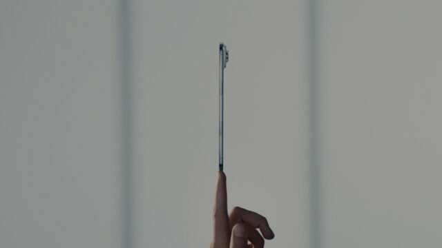 An iPhone appears to balance on a fingertip