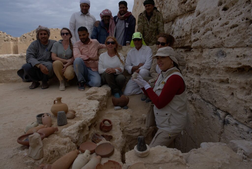 Martinez and her team post with various artifacts unearthed at the site.