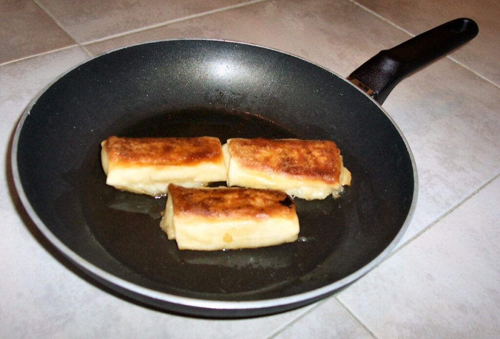 Freshly cooked frozen w:blintzes in a non-stick frying pan coated with Teflon
