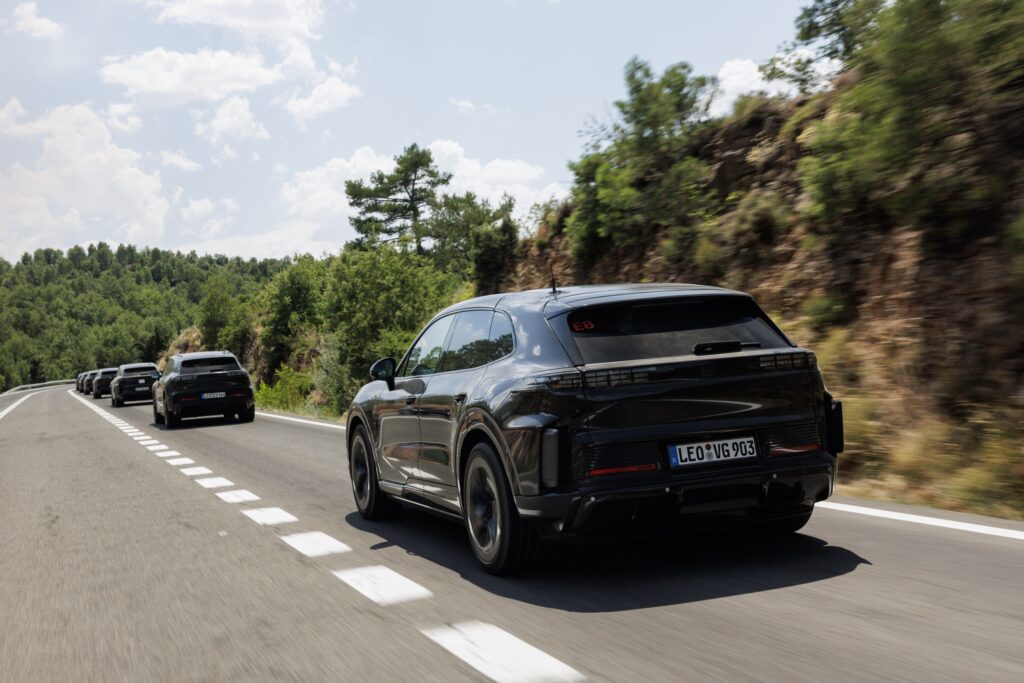 A convoy of prototype Porsche Cayenne EVs drives down a road