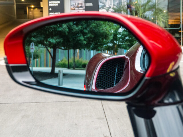 A view of a ferrari air intake seen in the car's wing mirror