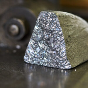 An oddly shaped hunk of metal, with a dull, oxidized color on most surfaces, but one showing freshly exposed material that has a silvery glint.