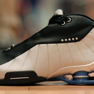 Image of a black and white athletic sneaker with an elaborate cushioning system in its heel.