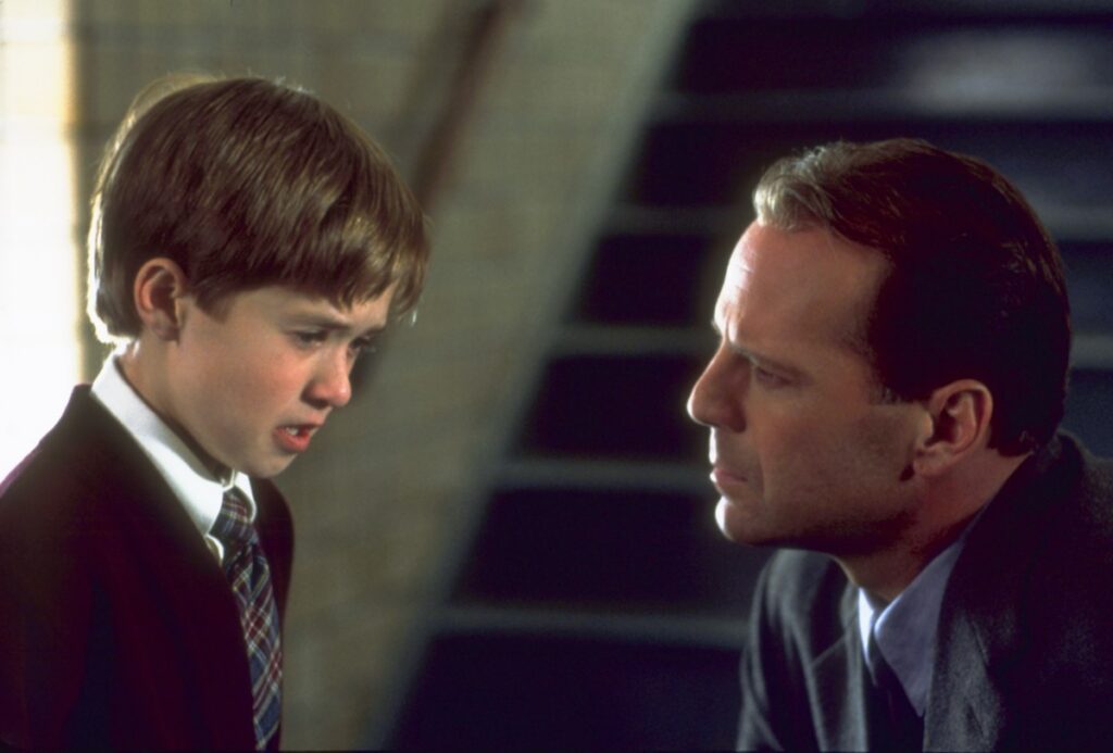 little boy looking scared being comforted by a man kneeling in front of him