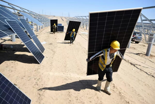workers carrying solar panels