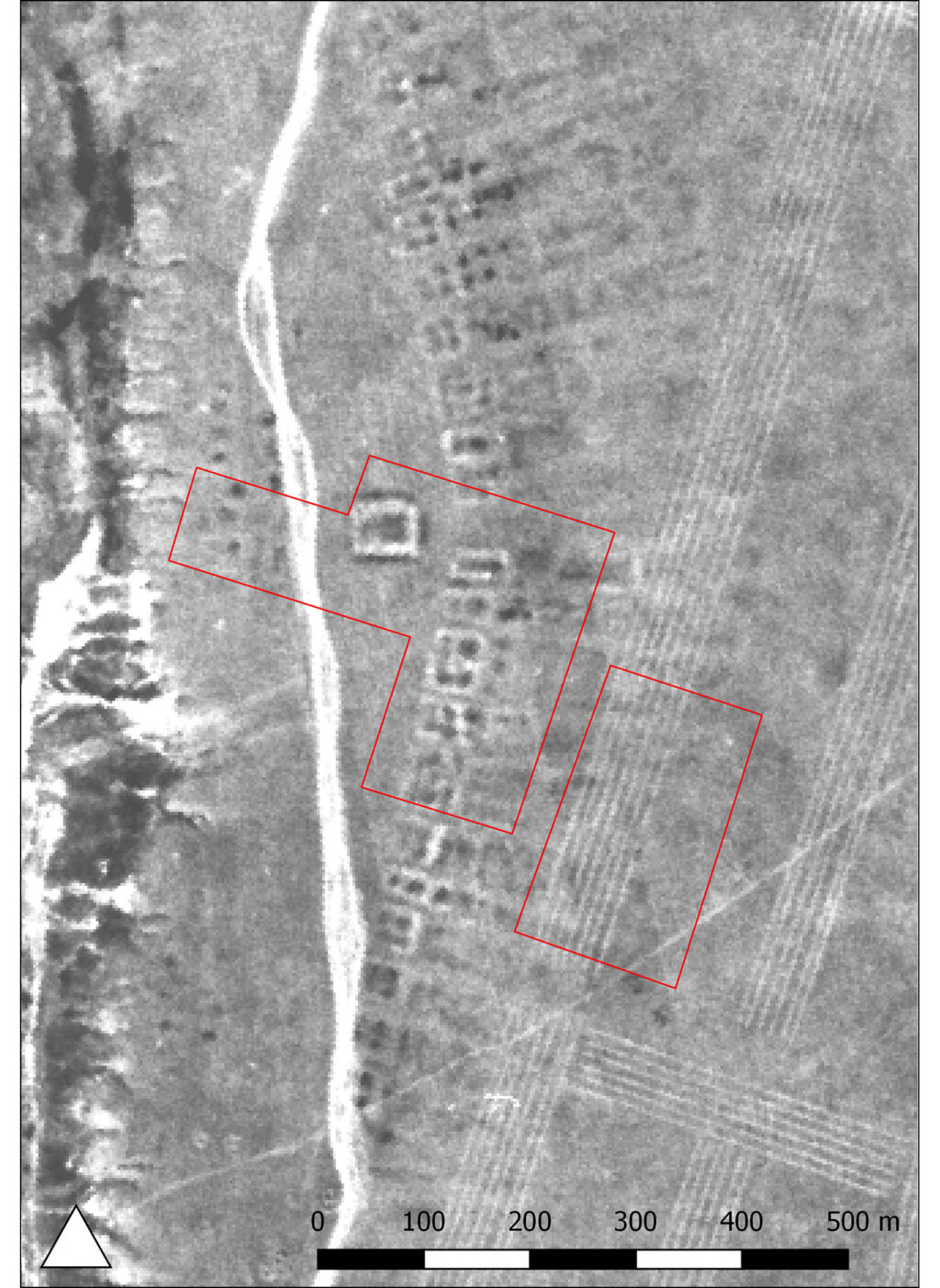 A grayscale satellite photo showing the outlines of building foundations underground