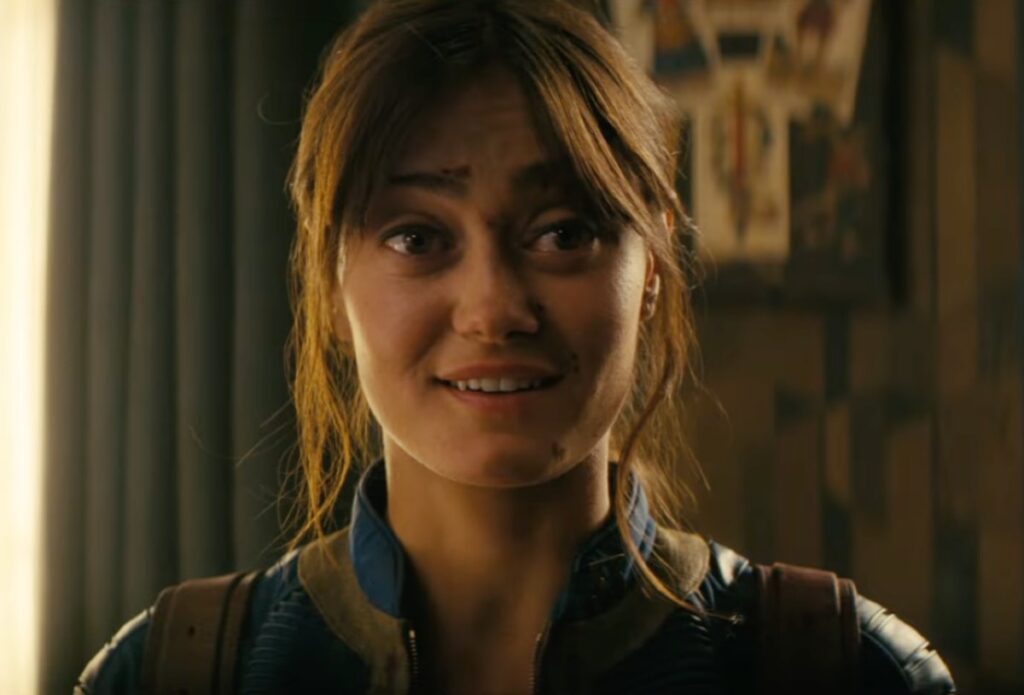 Giovane donna castana con la sporcizia sul viso che sorride leggermente alla macchina fotografica