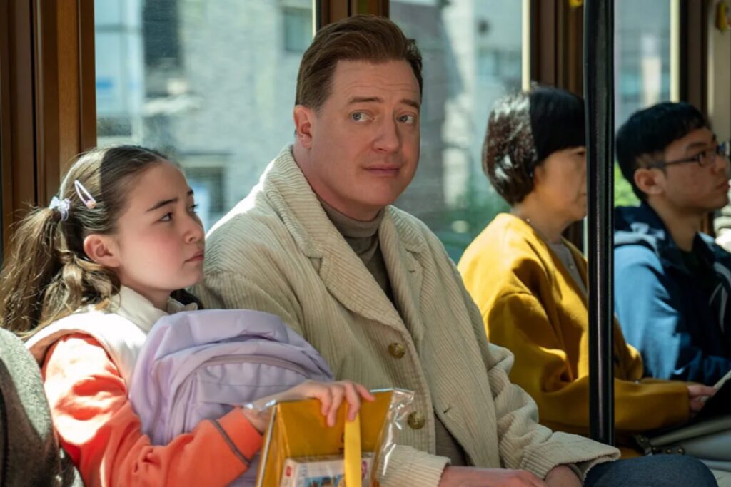 large man on a Japanese train next to a little Japanese girl and other commuters