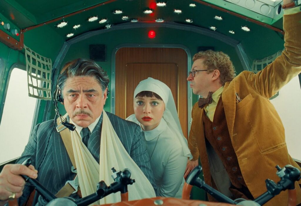 middle aged man, a nun, and a younger man in an airplane cabin