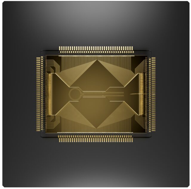 Image of a grey square with lots of wires heading into a gold chip with a complicated arrangement of channels on its surface.