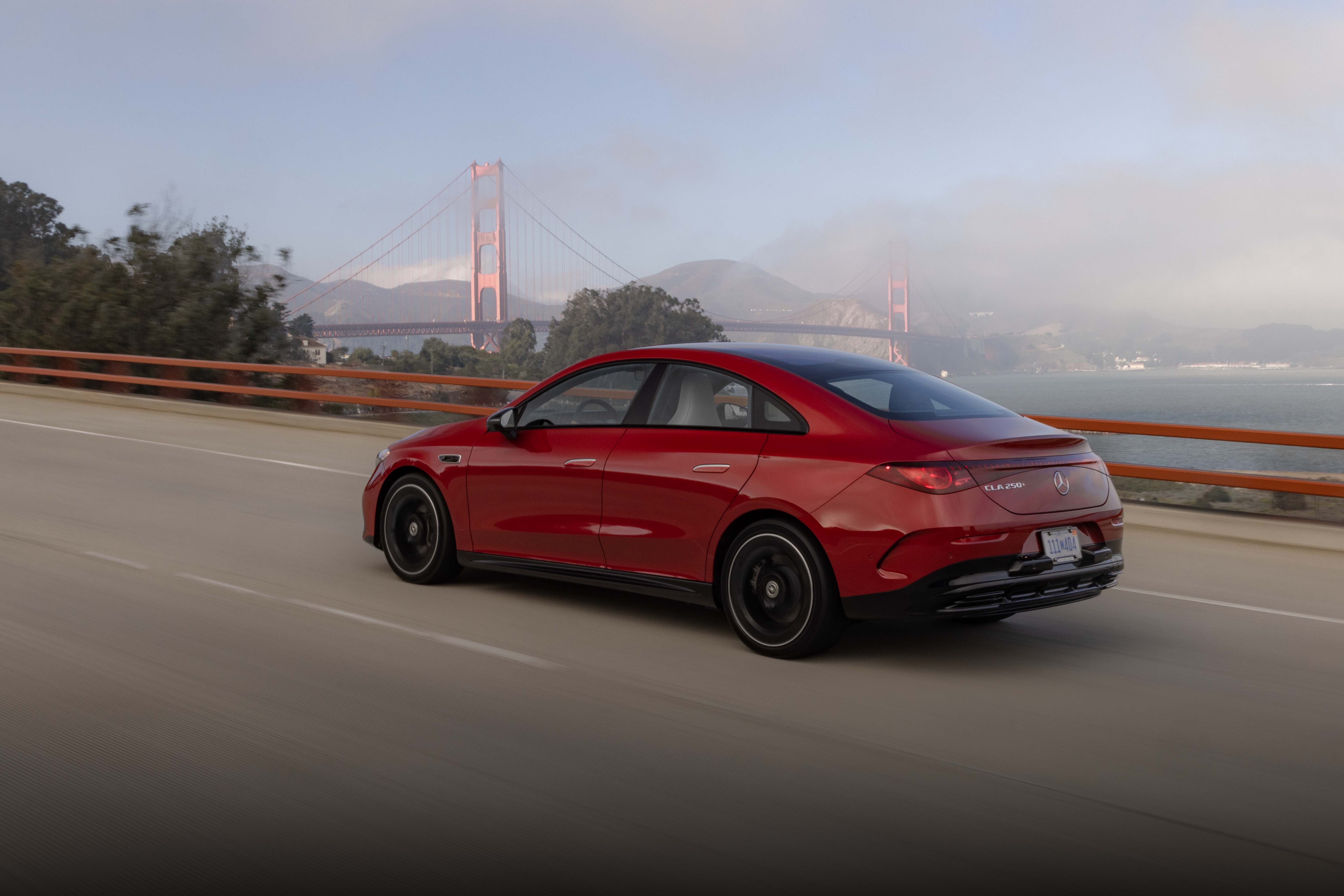 A red Mercedes-Benz CLA drives past the golden gate bridge