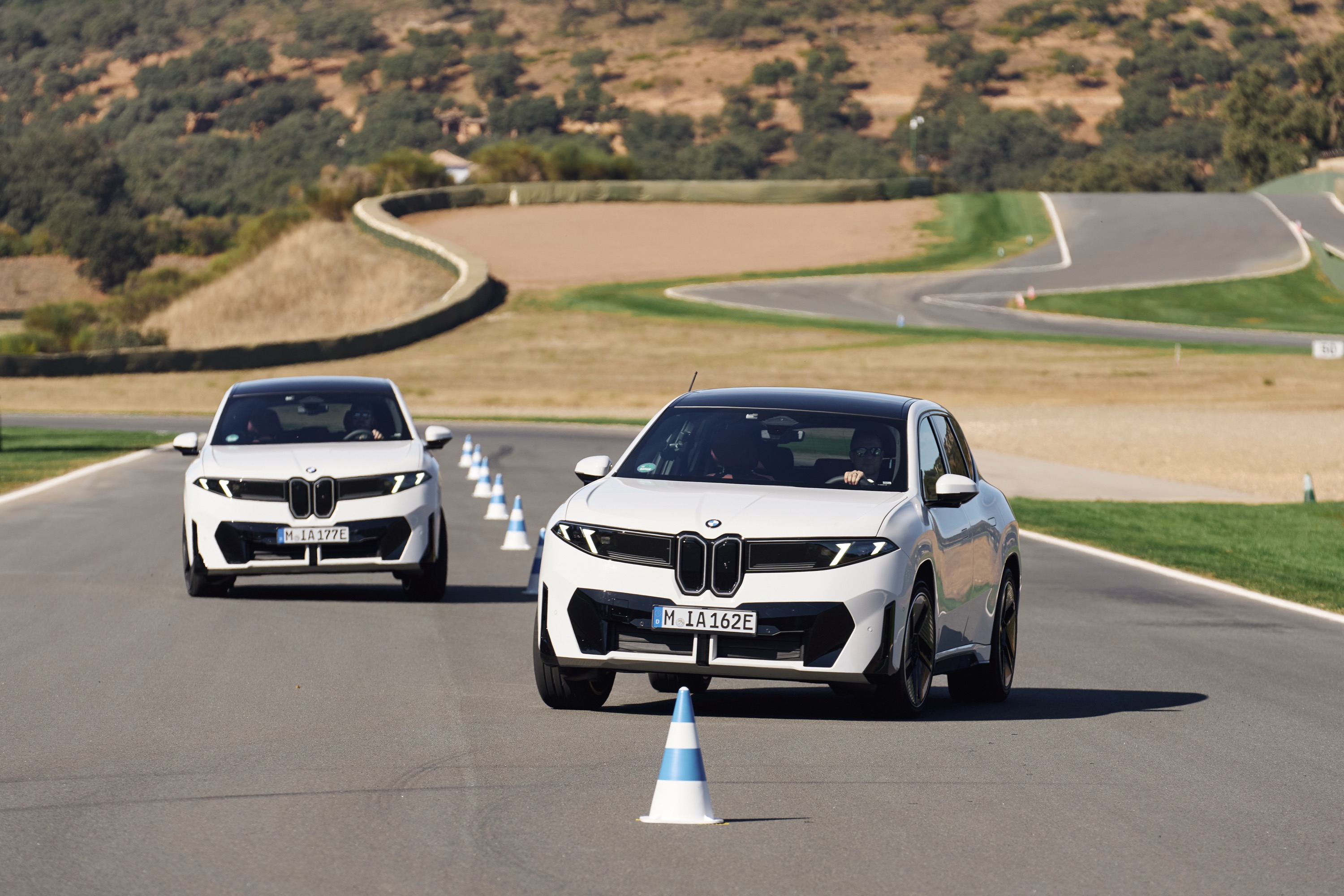Two BMW iX3s going through slalom cones