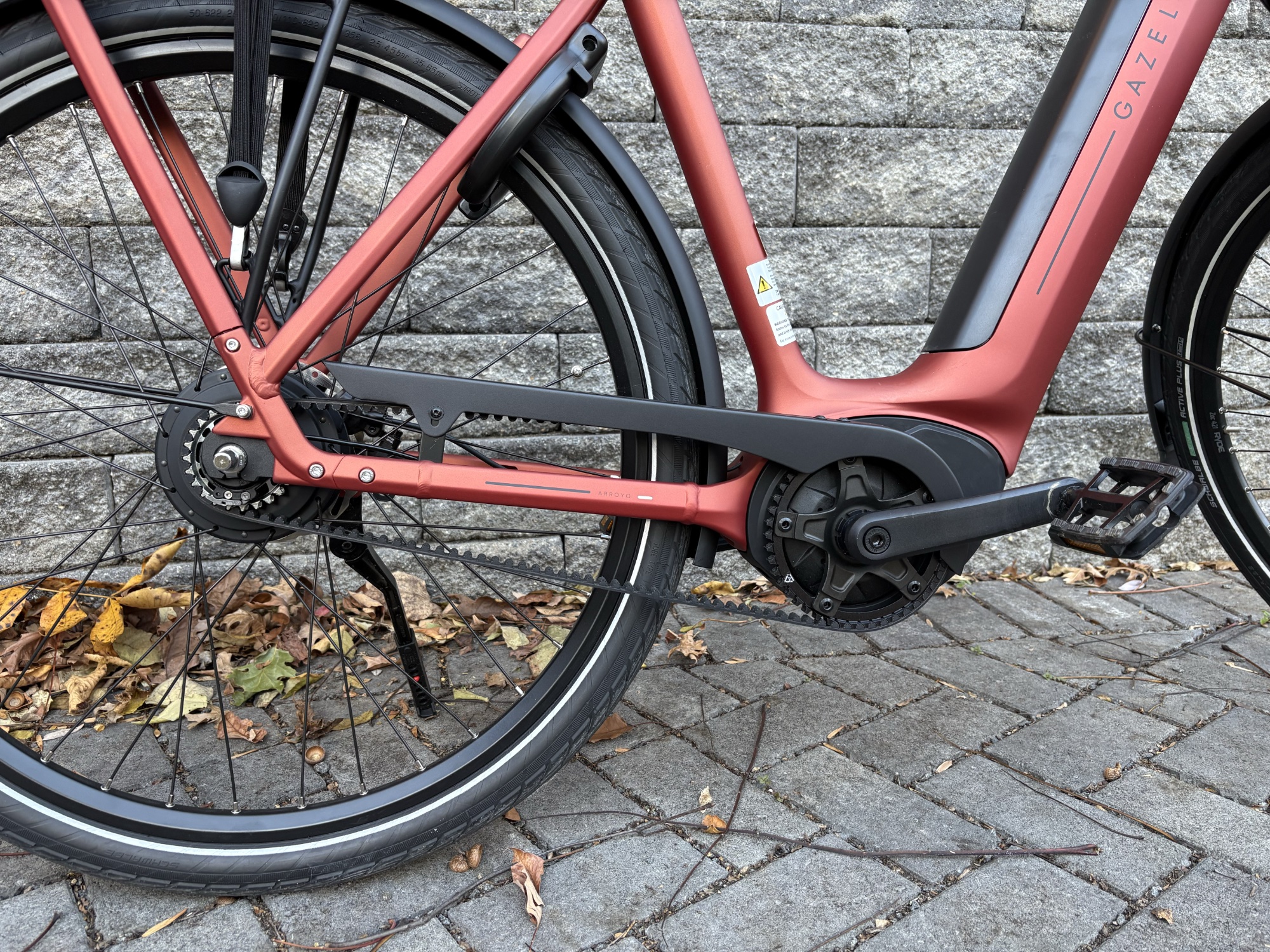 Image of the rear of an orange bike, showing the drive system and most of the rear wheel.
