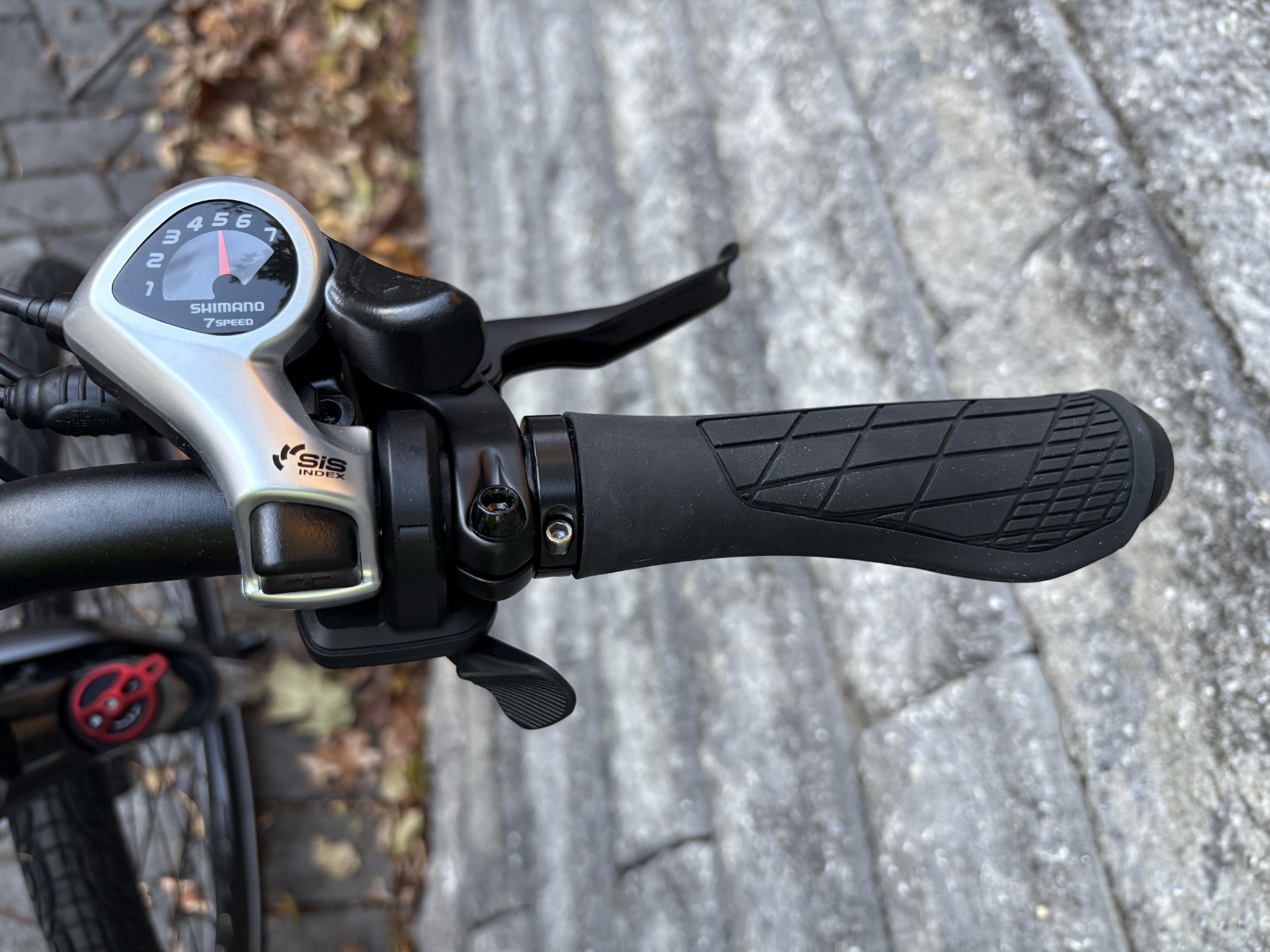 Image of the right handlebar of a bike, showing a shifter and a brake lever.