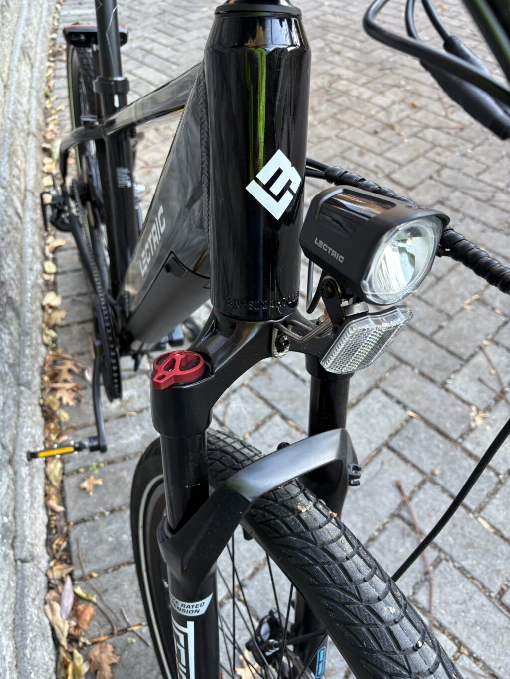 Image of the top of a front wheel of a bicycle, showing a suspension fork and the had tube of the frame.