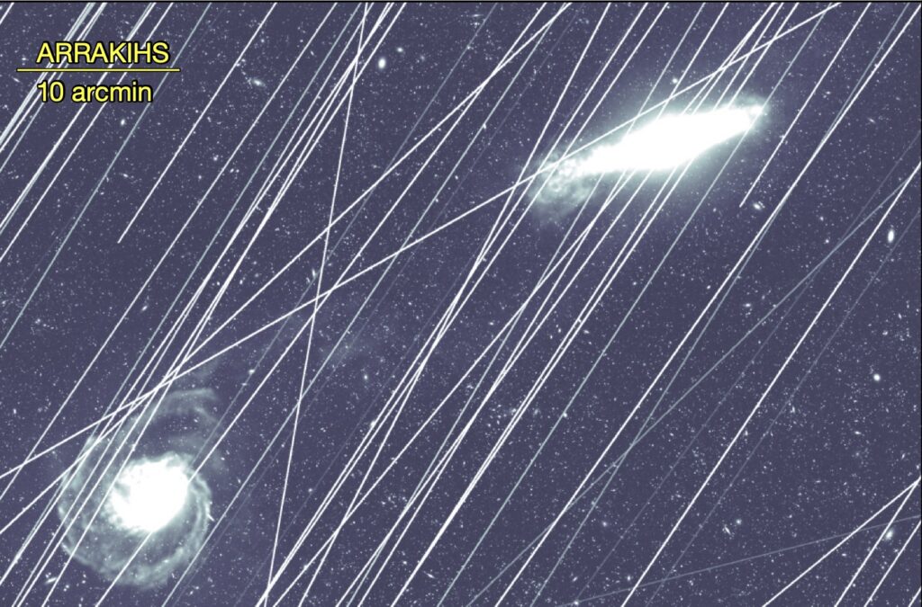 Greyscale image of two galaxies with a huge number of straight white lines crossing them.