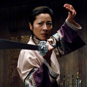 Michelle Yeoh in wuxia period garb brandishing a sword in a fighting stance
