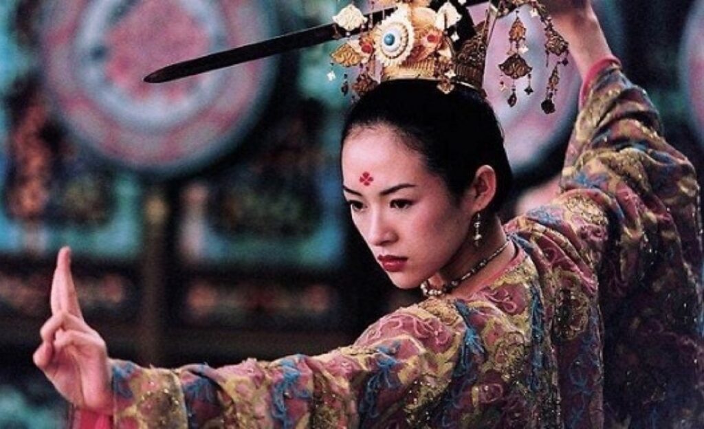 young asian woman in elaborate Chinese costume wielding a sword in fighting stance