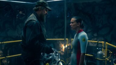 older man and young woman standing facing each other in a military facility