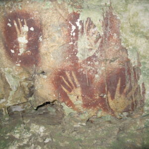 photo of pointy-fingered hand stencils on a cave wall