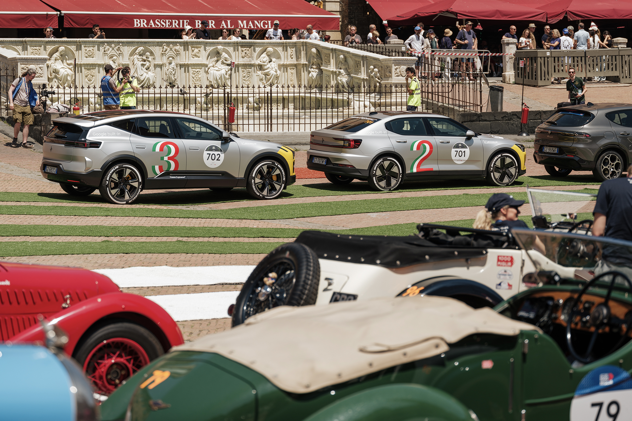 Two polestar 3s in the background, with vintage racing cars in the foreground.