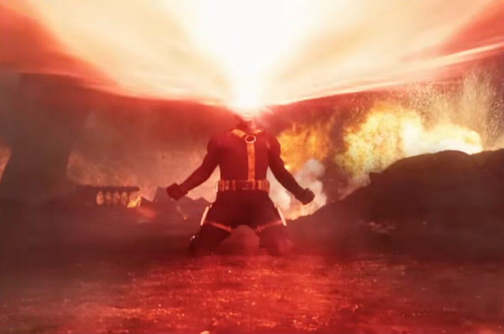 Figure in X Men uniform kneeing with arms outstretched and head thrown back as laser beams shoot from hs eyes.