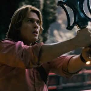 buff young blimp man in a reddish shirt holding a magic sword