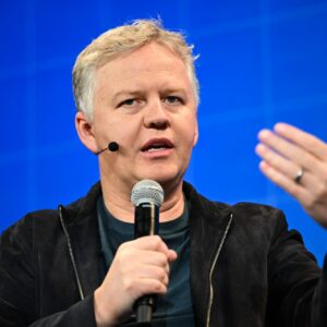 Cloudflare CEO Matthew Prince holding a microphone and speaking at a conference.