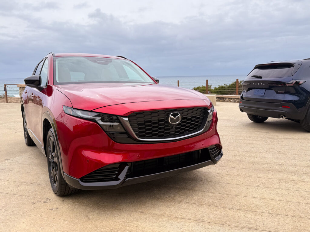 A red Mazda CX-5 with a blue one in the background.