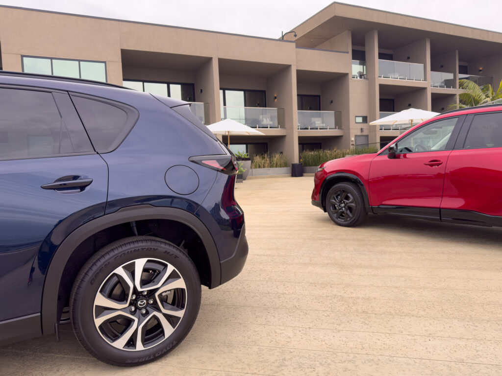 A blue Mazda CX-5 with a red one in the background.