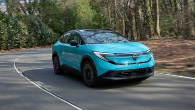 A Nissan Leaf drives towards the camera