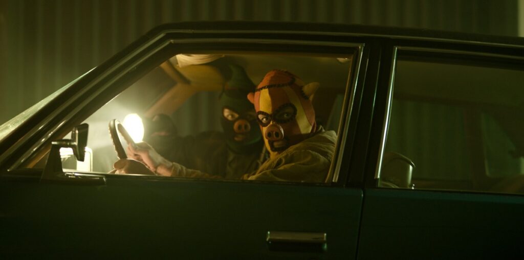 two men in a car wearing pig masks