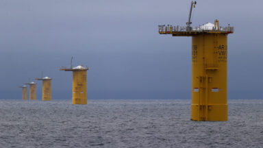 Image of a series of metal cylinders rising vertically from the ocean.