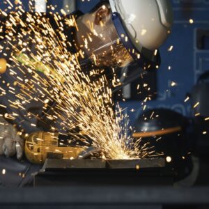 A man using a metal grinder causing sparks to fly.