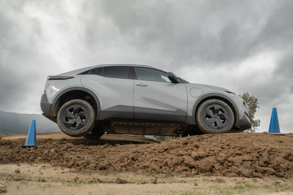 A Subaru Uncharted in profile, seen from below as it negotiates an off road course. The back passenger wheel is in the air