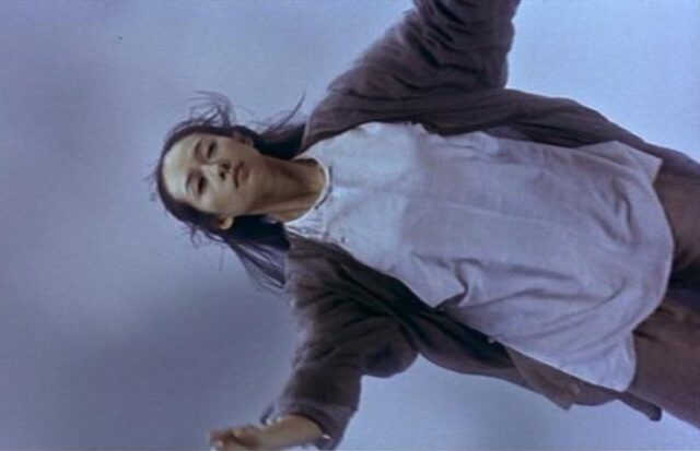 young woman in mid-air with an expression of peaceful acceptance.