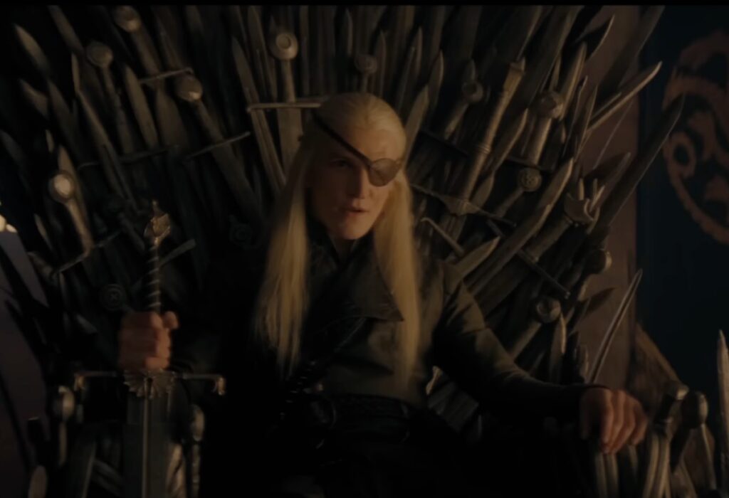 man in black with long white hair and an eye patch sits on the iron throne.