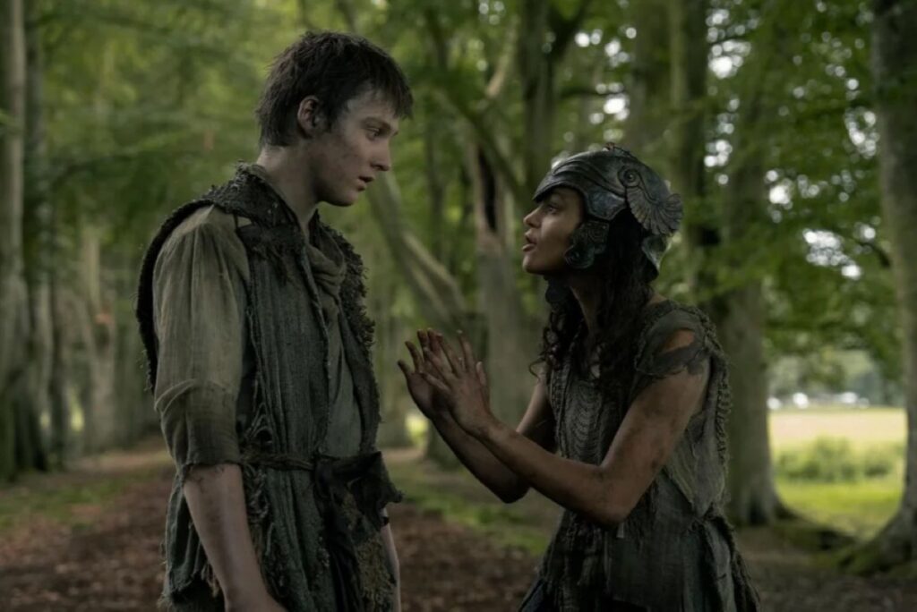 young boy and girl dressed in rags in the woods